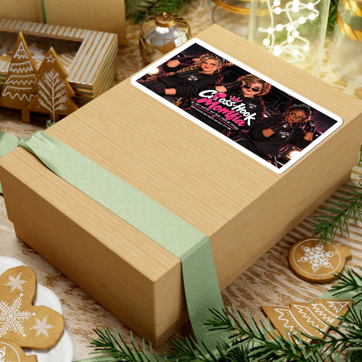 Large view of sticker prominently displayed on a holiday-wrapped gift box with cookies and greenery.