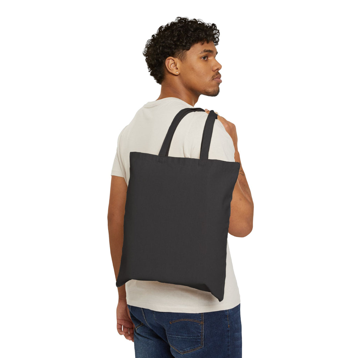 Person carrying plain black canvas tote, no design