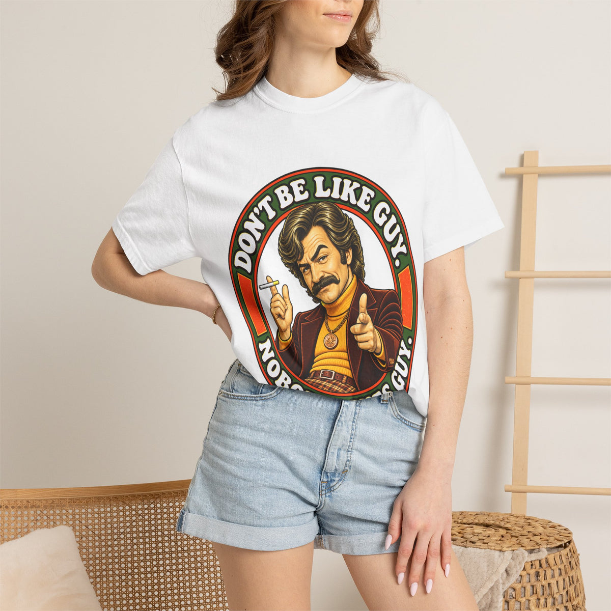 Model wearing white retro t-shirt featuring large 'Don’t Be Like Guy' print on front