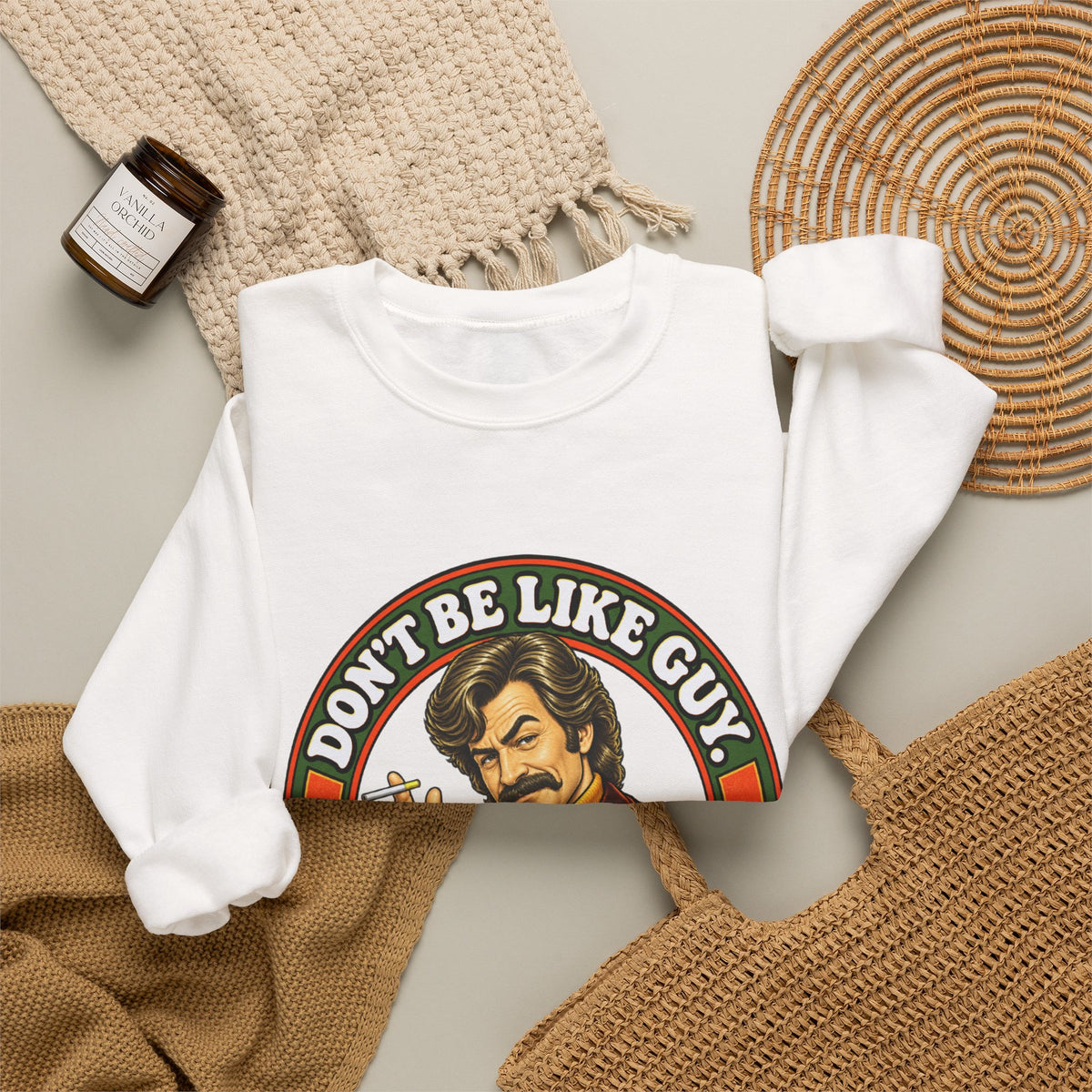 Lifestyle shot of white 'Don't Be Like Guy' sweatshirt with home decor