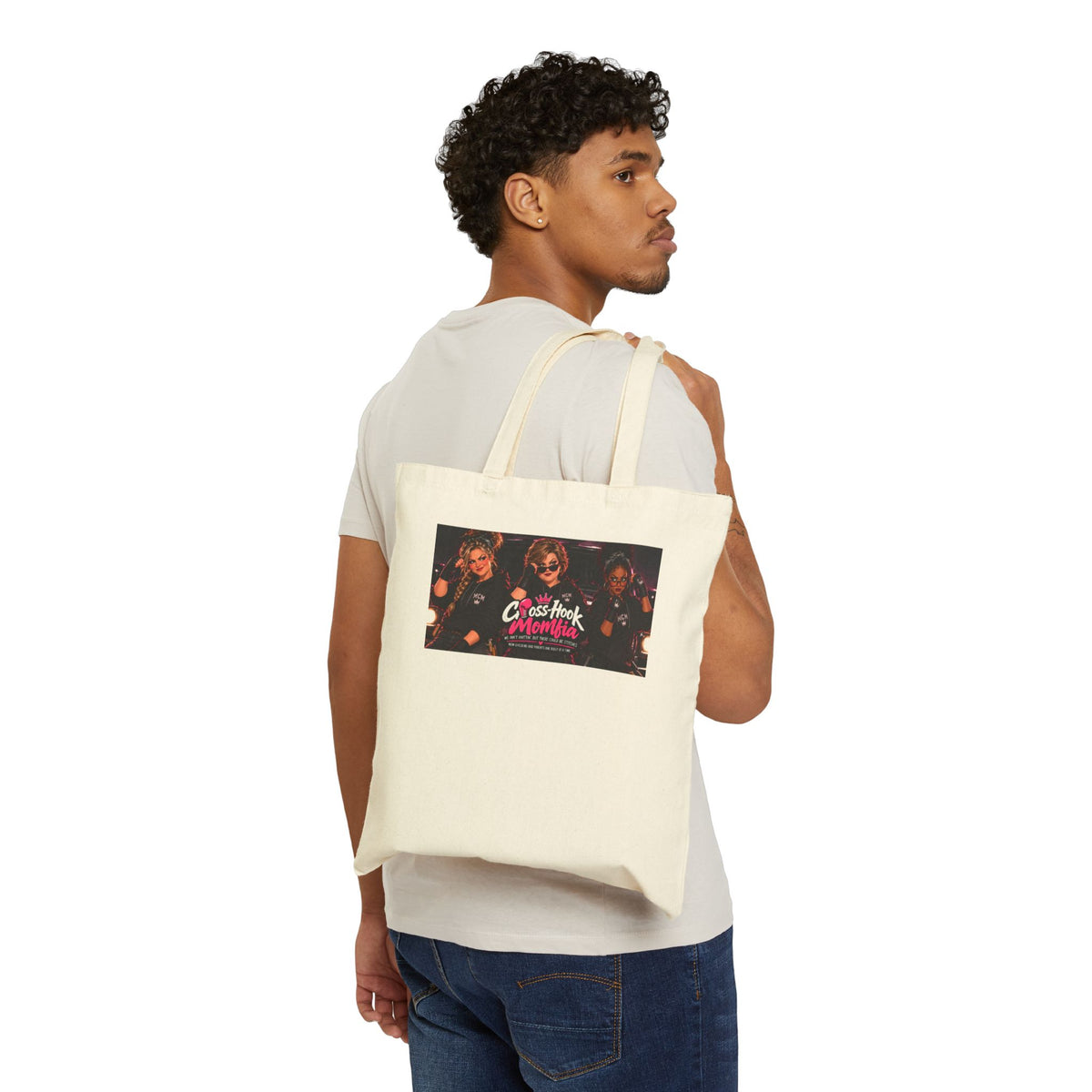 Man carrying natural canvas tote bag with Cross Hook Momfia design