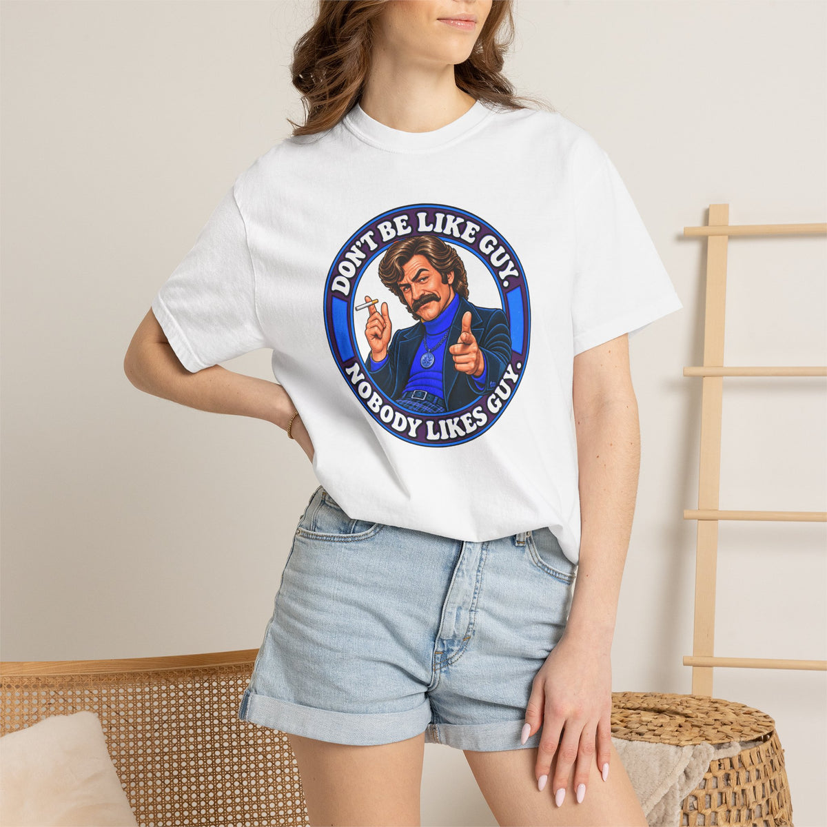 Woman wearing white Don’t Be Like Guy t-shirt and denim shorts