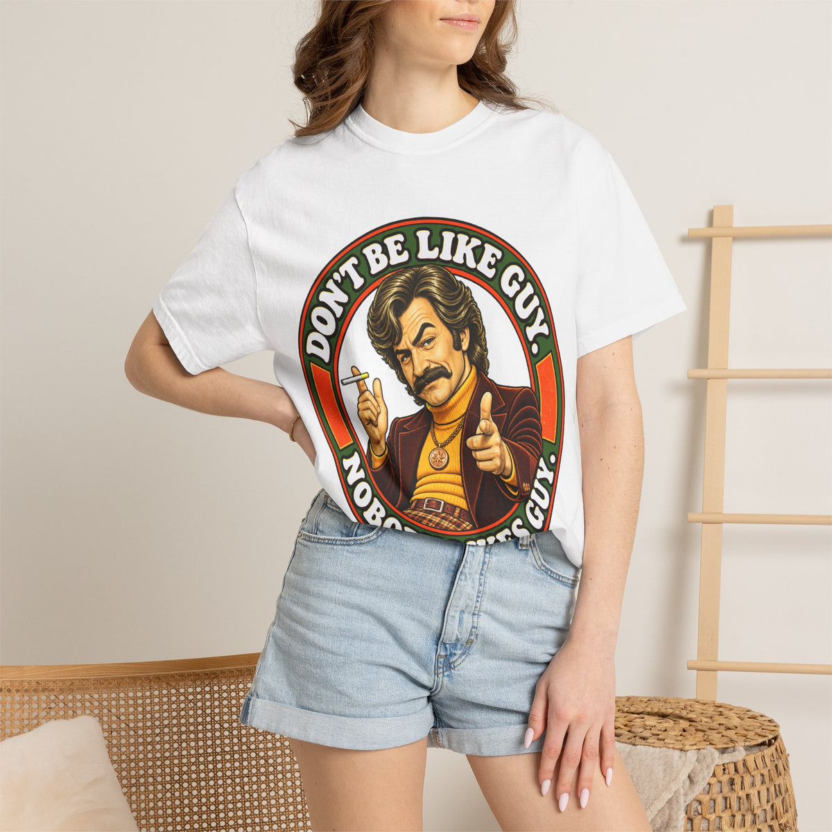 Model wearing white 'Don't Be Like Guy' retro graphic shirt
