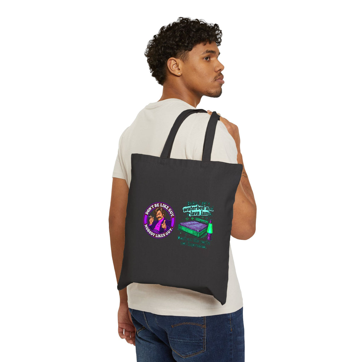 Person carrying black canvas tote bag with retro cat and lamp graphic