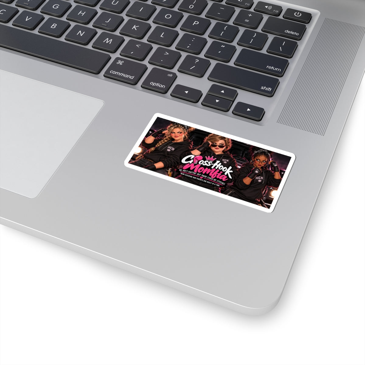 Sticker placed on a silver laptop, displaying retro 'Cross-Hook Momfia' design.