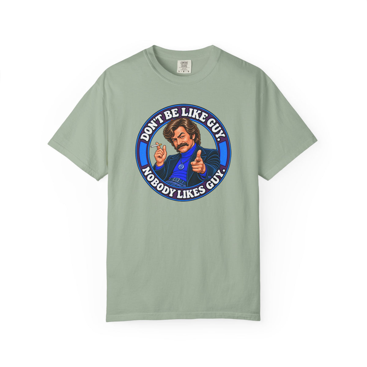 Sage green t-shirt with Don’t Be Like Guy cartoon and text on front