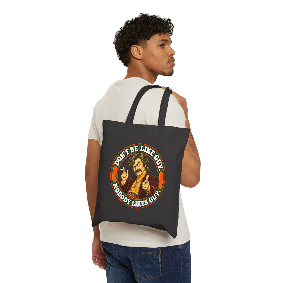 Model carrying black cotton tote bag with 'Don't Be Like Guy' graphic
