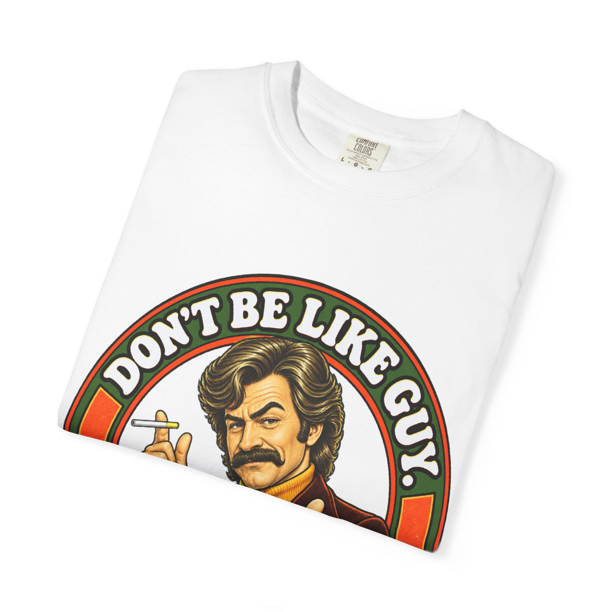 Folded white t-shirt displaying the bold 'Don’t Be Like Guy' retro graphic
